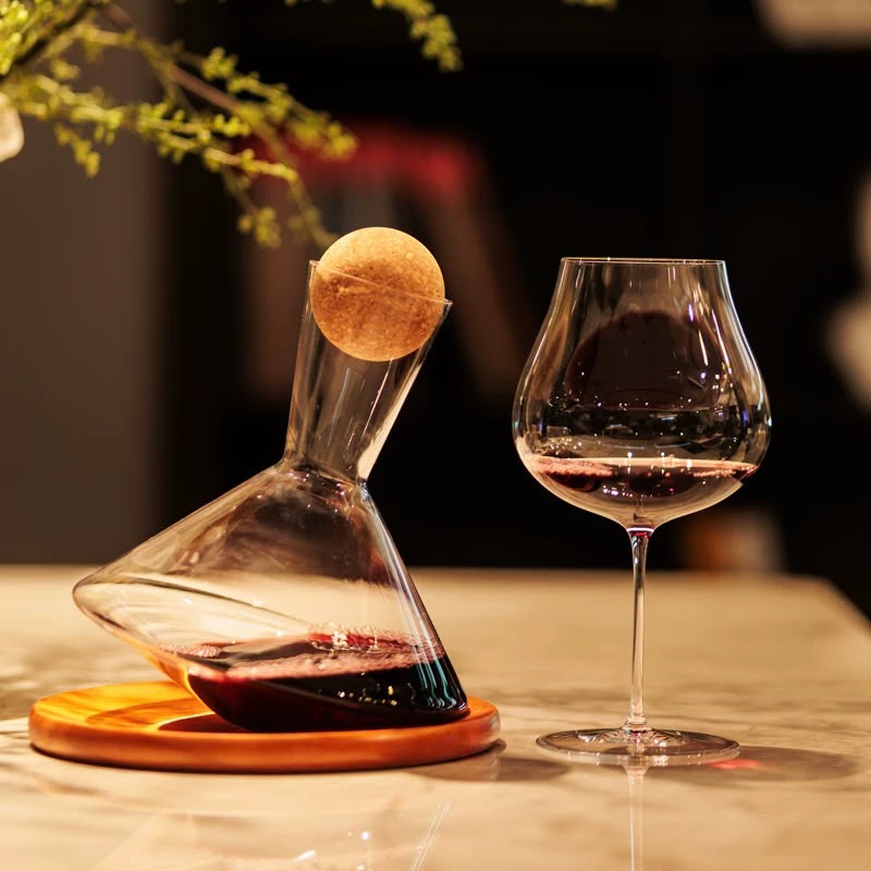 A Persephaure wine glass beside a decanter in an elegant presentation